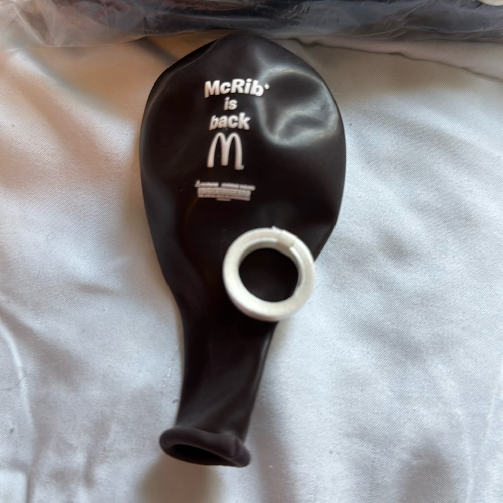 Over a dozen McRib McDonald’s balloons with ribbon spools